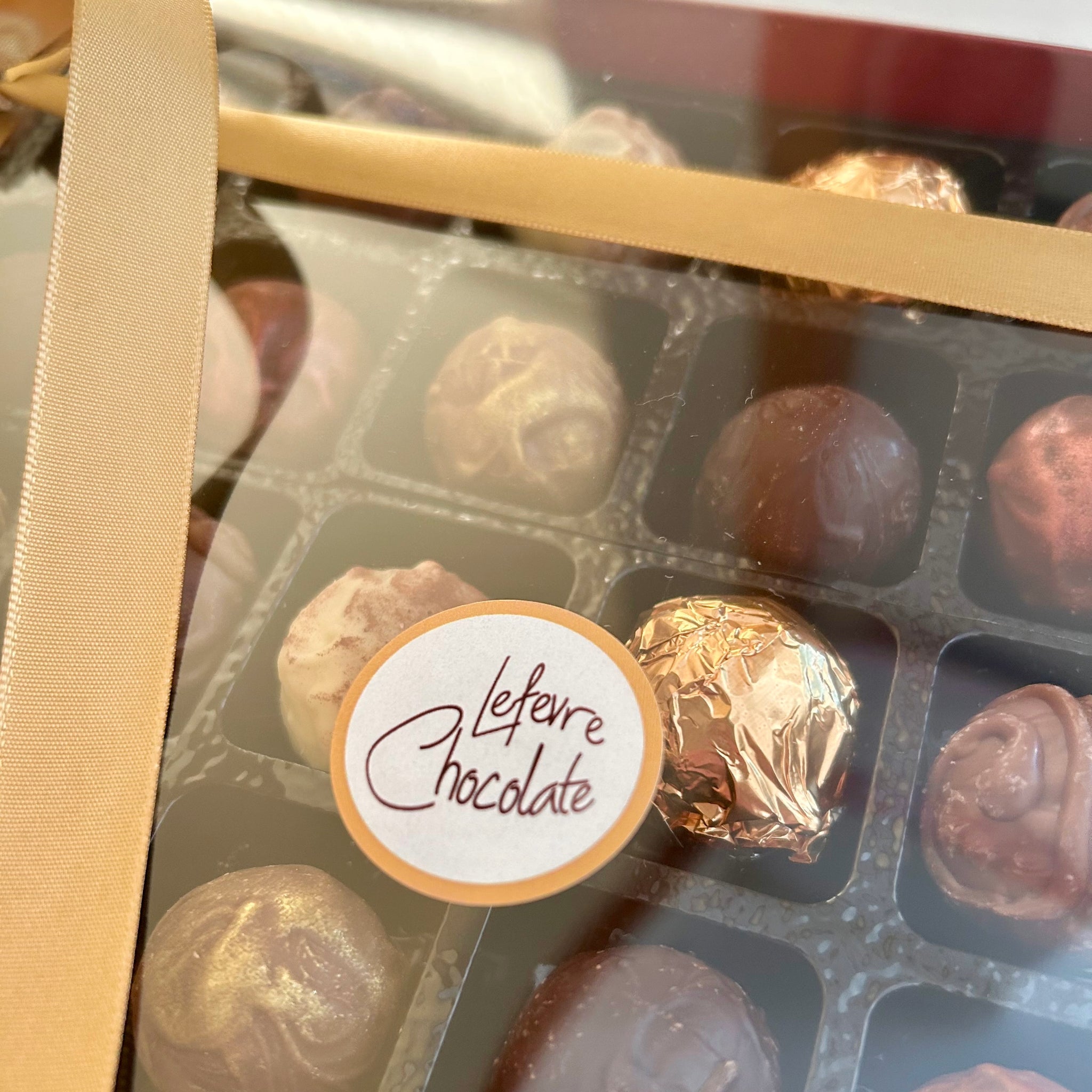 Close-up of 24 handcrafted Belgian chocolate truffles with rich ganache centres, presented in a premium gift box by Lefevre Chocolate